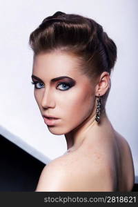 Portrait of beautiful fashionable woman with earrings - stylish styling coiffure (hairstyle)