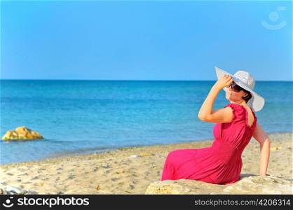Portrait of beautiful female in red dress on beach