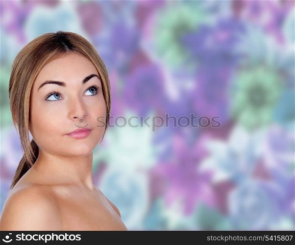 Portrait of beautiful female model looking up with a floral background