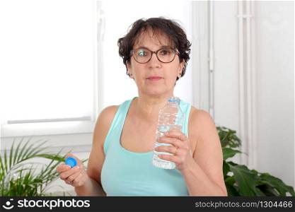 Portrait of beautiful fitness mature woman with water bottle