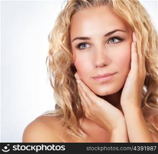 Portrait of beautiful gentle blond woman over clean background, using natural cosmetics in spa salon, beauty treatment
