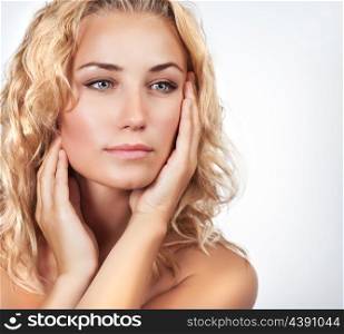 Portrait of beautiful gentle blond woman over light background, using natural cosmetics in spa salon, beauty treatment