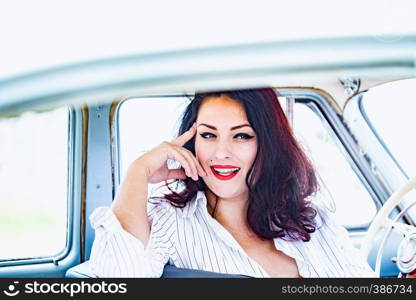 portrait of beautiful girl in a retro car in style pin up