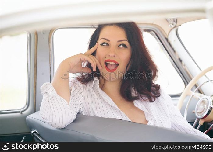 portrait of beautiful girl in a retro car in style pin up