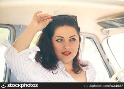 portrait of beautiful girl in a retro car in style pin up