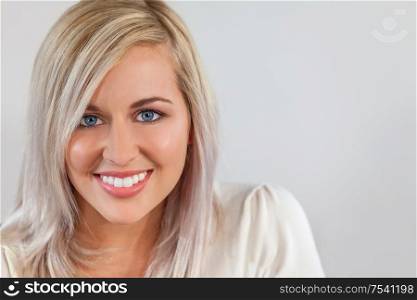 Portrait of beautiful girl or young woman smiling with perfect teeth and bright blue eyes