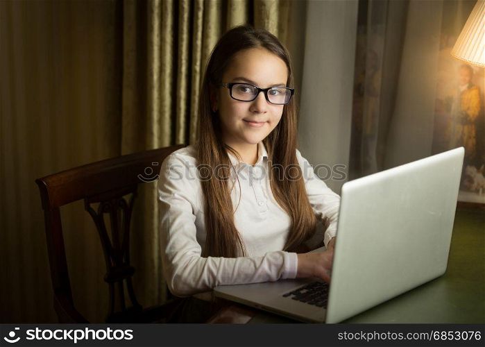 Portrait of beautiful girl using laptop at late evening