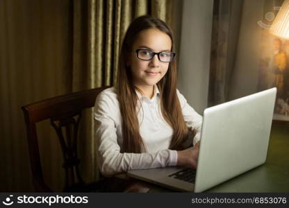 Portrait of beautiful girl using laptop at late evening