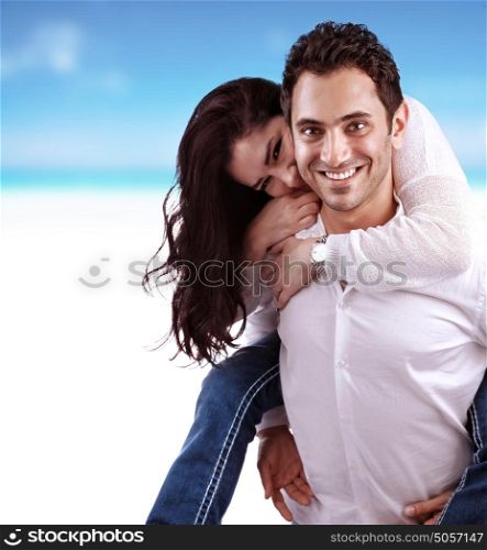 Portrait of beautiful happy couple on the beach, handsome man holding his girlfriend piggy back, romantic date, young family concept