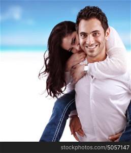 Portrait of beautiful happy couple on the beach, handsome man holding his girlfriend piggy back, romantic date, young family concept