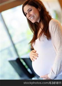 Portrait of beautiful happy pregnant woman at home, having a good time, enjoying pregnancy, healthy lifestyle