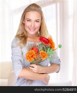 Portrait of beautiful happy woman with autumn flowers at home, receive gift on Thanksgiving day, happiness concept