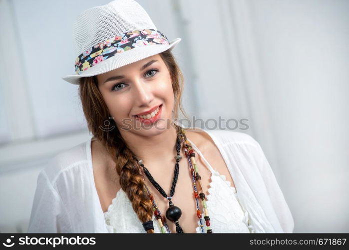 portrait of beautiful hippie girl with a white summer hat