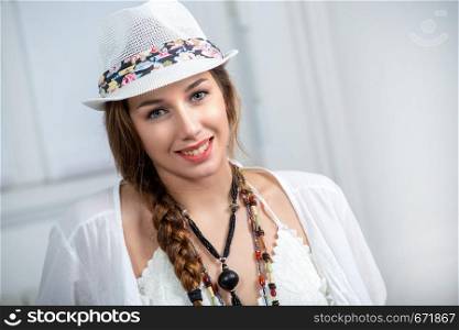 portrait of beautiful hippie girl with a white summer hat