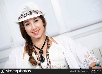 portrait of beautiful hippie girl with a white summer hat