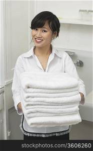 Portrait of beautiful housemaid holding white towels