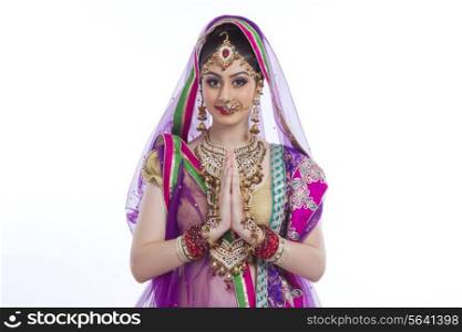 Portrait of beautiful Indian bride greeting over white background