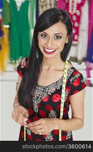 Portrait of beautiful Indian female tailor smiling