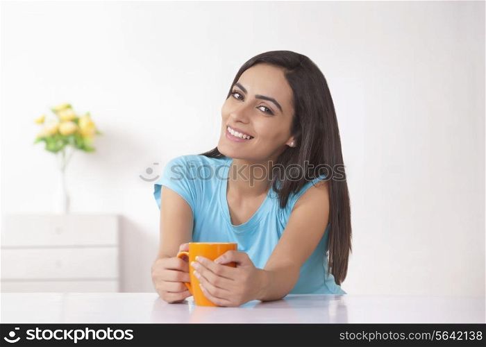 Portrait of beautiful Indian woman having coffee at home