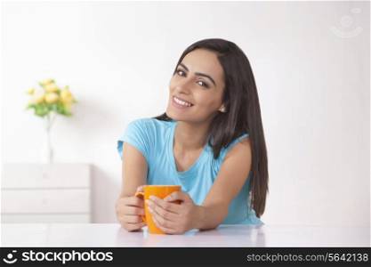 Portrait of beautiful Indian woman having coffee at home