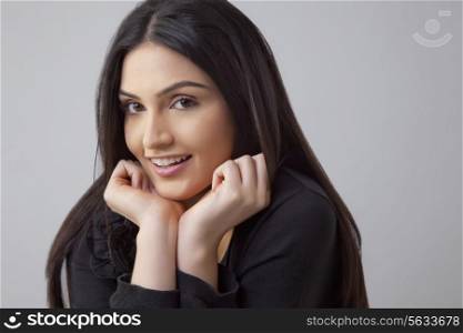 Portrait of beautiful Indian woman smiling over colored background