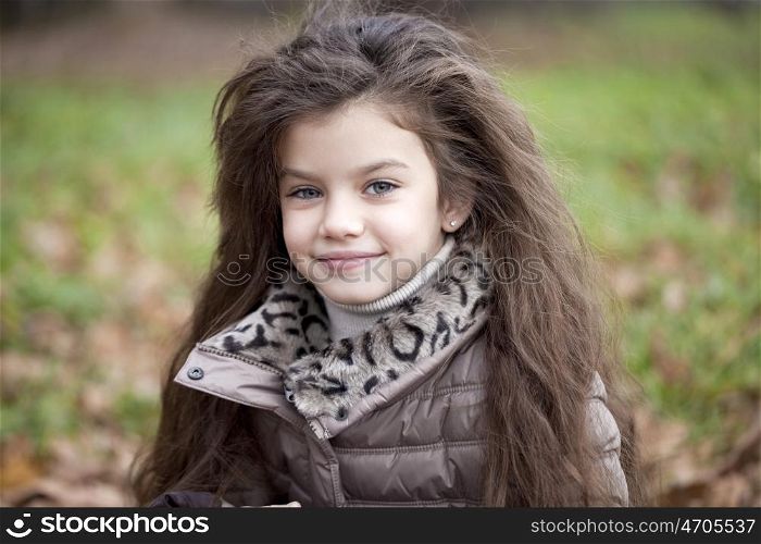 Portrait of beautiful little girl, against background of autumn park