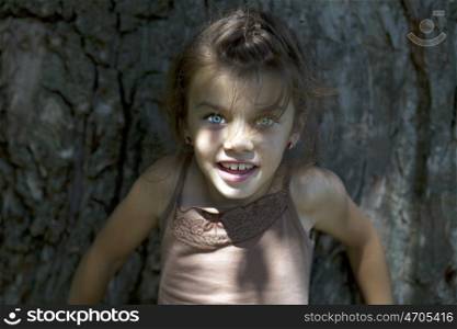 Portrait of beautiful little girl, against background of summer park