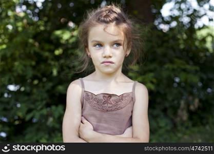 Portrait of beautiful little girl, against background of summer park