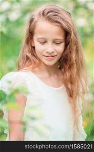Portrait of beautiful little girl in blooming apple tree garden on spring day. Adorable little girl in blooming apple garden on beautiful spring day