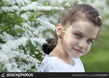 Portrait of beautiful little girl in spring blossom