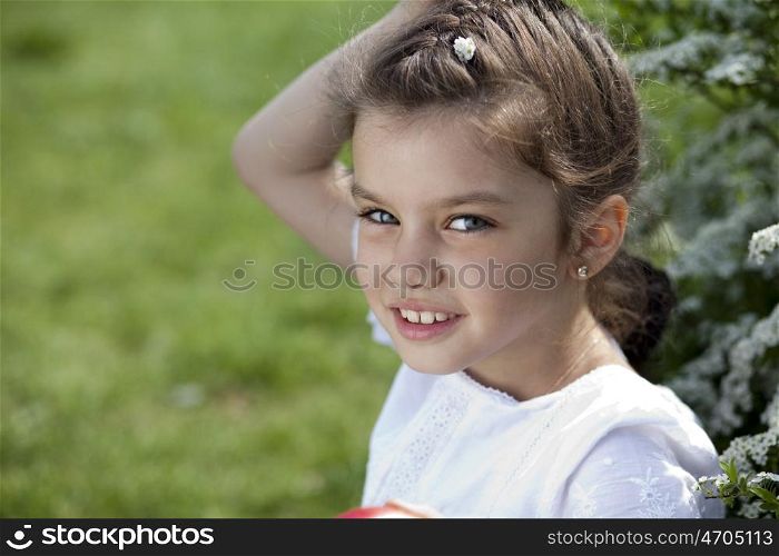 Portrait of beautiful little girl in spring blossom