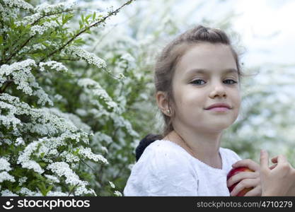 Portrait of beautiful little girl in spring blossom