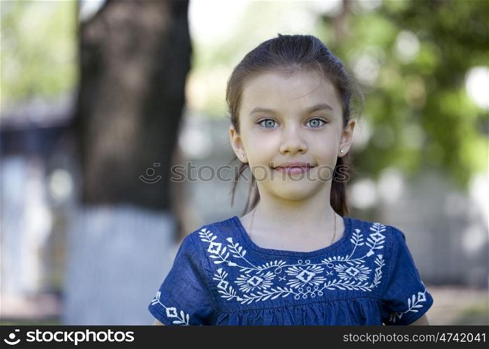 Portrait of beautiful little girl in summer park