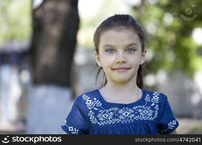 Portrait of beautiful little girl in summer park