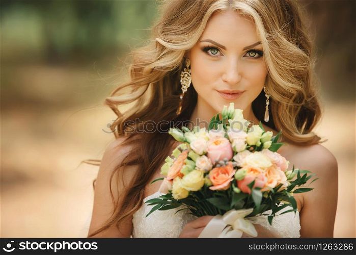 Portrait of beautiful luxury bride with roses wedding bouquet outdoors. Young woman with professional make up and hair style. Wedding day. Marriage. Portrait of beautiful luxury bride with roses wedding bouquet outdoors. Young woman with professional make up and hair style. Wedding day. Marriage.