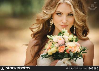 Portrait of beautiful luxury bride with roses wedding bouquet outdoors. Young woman with professional make up and hair style. Wedding day. Marriage. Portrait of beautiful luxury bride with roses wedding bouquet outdoors. Young woman with professional make up and hair style. Wedding day. Marriage.