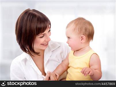 Portrait of beautiful mother with cute adorable little daughter at home, happy young family, love and happiness concept