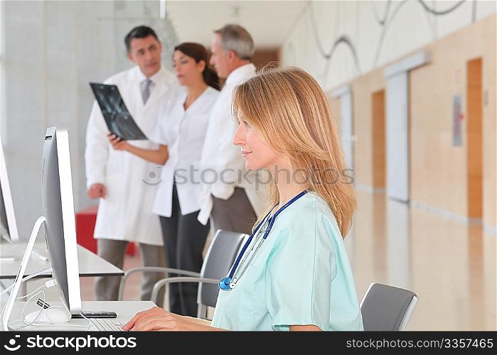 Portrait of beautiful nurse in front of medical people