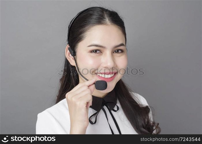 Portrait of beautiful operator woman on gray background