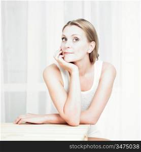 Portrait of beautiful pensive girl at table