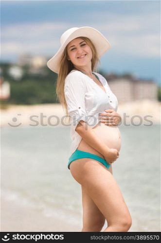 Portrait of beautiful pregnant woman posing at sea