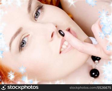 portrait of beautiful redhead with finger on lips