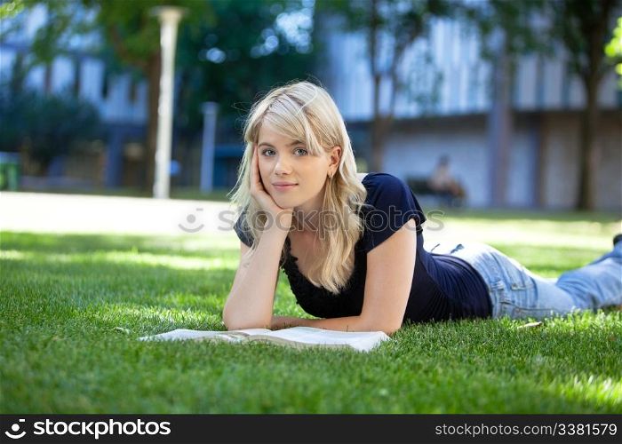 Portrait of beautiful relaxed young female student with a book