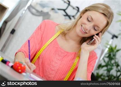 portrait of beautiful seamstress talking on the phone