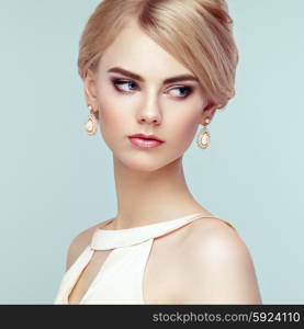 Portrait of beautiful sensual woman with elegant hairstyle. Perfect makeup. Blonde girl. Fashion photo. Jewelry and dress