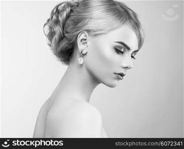 Portrait of beautiful sensual woman with elegant hairstyle. Perfect makeup. Blonde girl. Fashion photo. Jewelry and dress. Black and white