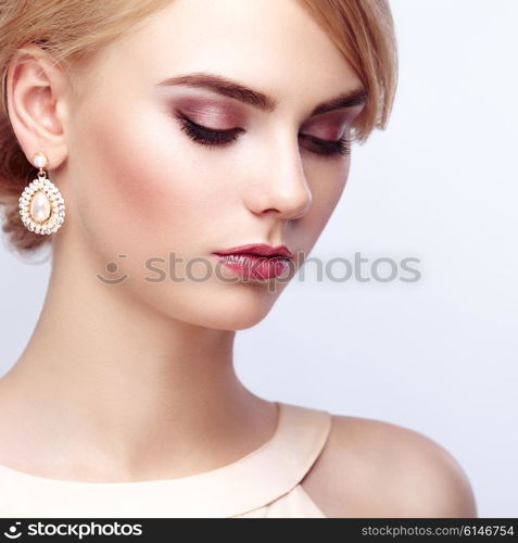 Portrait of beautiful sensual woman with elegant hairstyle. Perfect makeup. Blonde girl. Fashion photo. Jewelry and dress