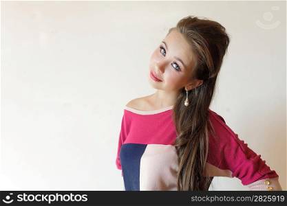 Portrait of beautiful sexual girl in jeans, standing near a wall, in fashion style, indoors