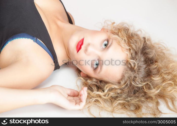 Portrait of beautiful sexy blonde girl lying on floor. Studio shot. Fashion and female beauty.