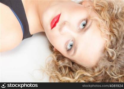 Portrait of beautiful sexy blonde girl lying on floor. Studio shot. Fashion and female beauty.